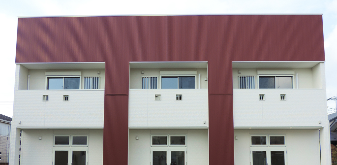 赤いアクセントカラーのあるモダンな3階建て